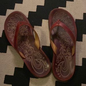 Dark red leather Olukai flip flops.